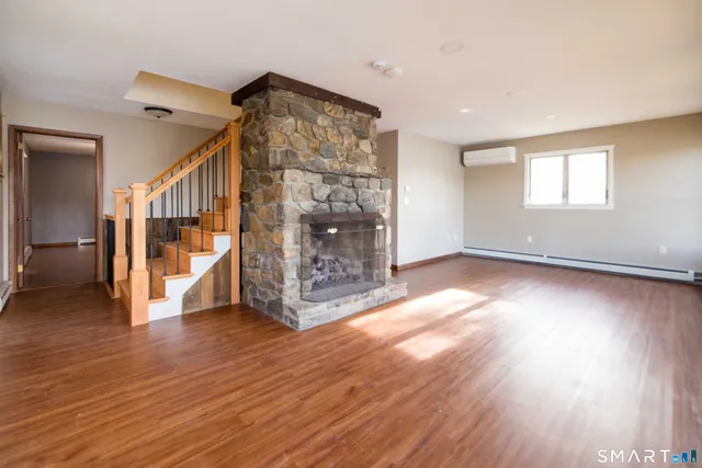 an empty room with wooden floor and fireplace