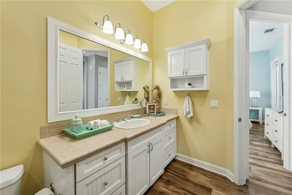 a spacious bathroom with a granite countertop sink and a mirror