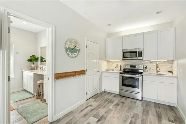 a kitchen with white cabinets and appliances