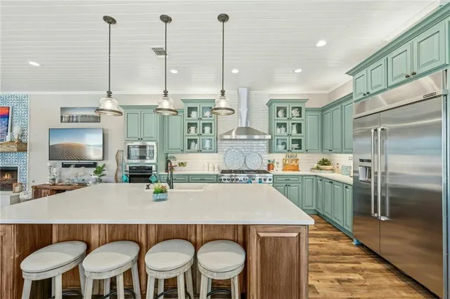 a kitchen with stainless steel appliances a dining table chairs and white cabinets