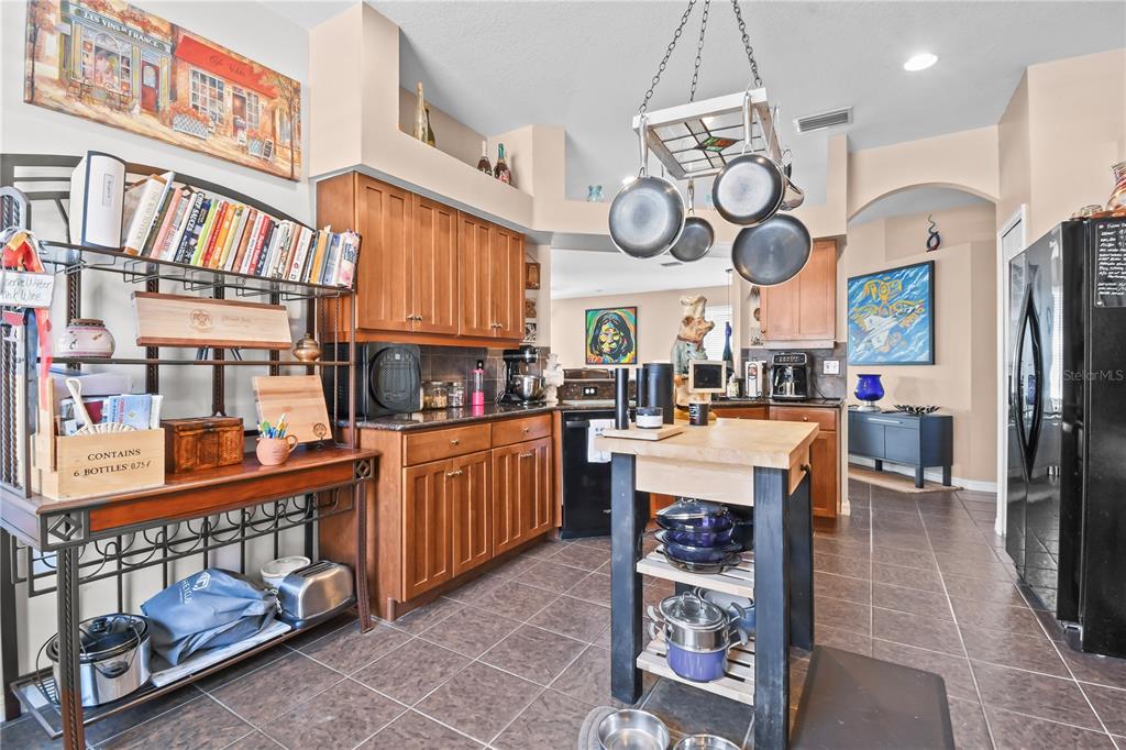 11130 Rodeo Lane Riverview, FL 33579 - Photo 12 of 49 a large white kitchen with stainless steel appliances granite countertop a stove a refrigerator a oven a dining table and chairs with the view of living room