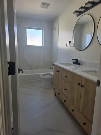 a bathroom with a double vanity sink and a mirror