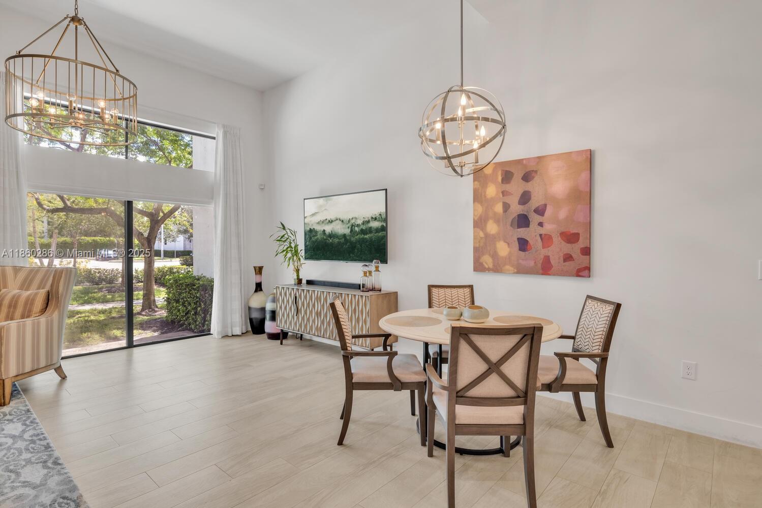 4444 Northwest 8th Court Plantation, FL 33317 - Photo 7 of 40 a view of a dining room with furniture wooden floor and a chandelier