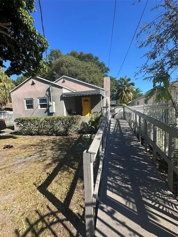 a view of a house with backyard and sitting area