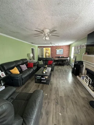 a living room with furniture kitchen view and a wooden floor