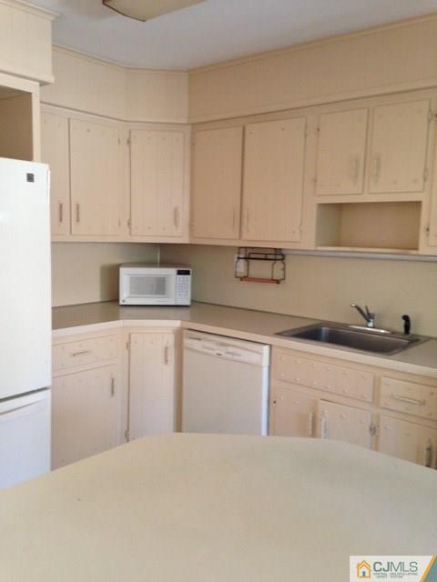 171 Midfield Road Colonia, NJ 07067 - Photo 3 of 12 a kitchen with granite countertop white cabinets and white appliances