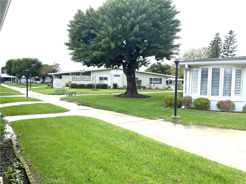 1621 Monterey Road Seal Beach, CA 90740 - Photo 3 of 10 a view of a house with a big yard and potted plants and large trees