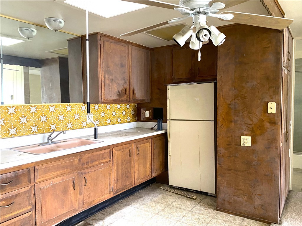 1621 Monterey Road Seal Beach, CA 90740 - Photo 8 of 10 a kitchen with stainless steel appliances granite countertop a sink a refrigerator a dining table and chairs
