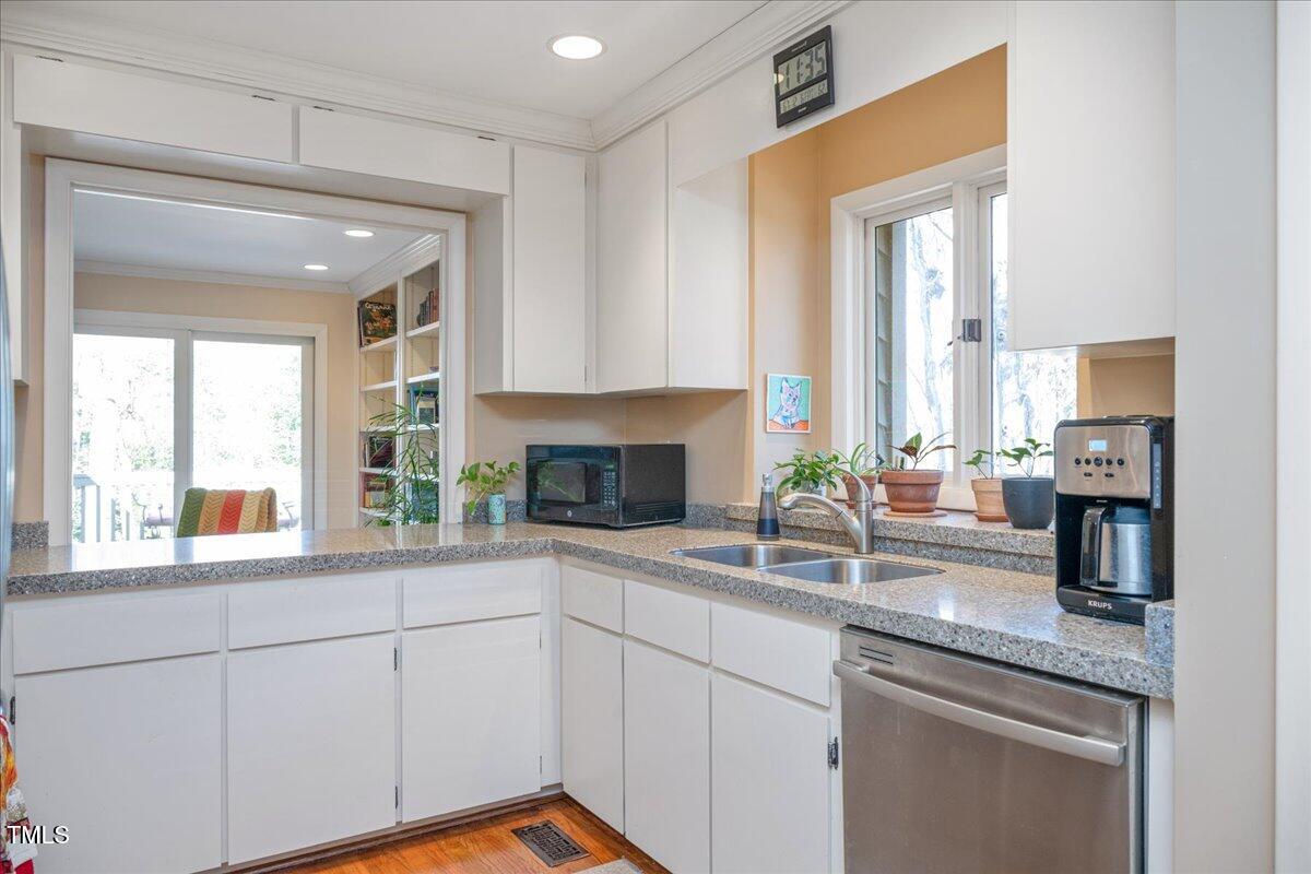 55 Stoneridge Road Durham, NC 27705 - Photo 19 of 35 a kitchen with granite countertop a sink and white cabinets