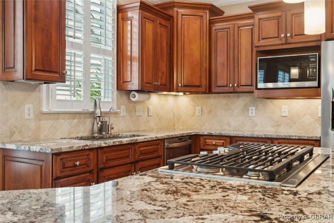 3013 Ridge Drive Toano, VA 23168 - Photo 20 of 50 Kitchen featuring tasteful backsplash, a sink, brown cabinets, appliances with stainless steel finishes, and light stone countertops