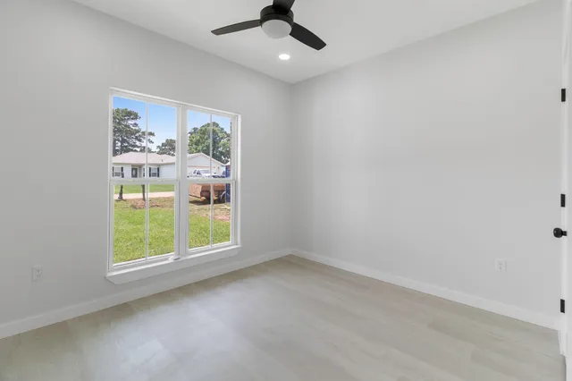 an empty room with window ceiling fan and carpet