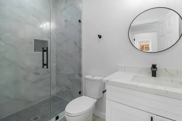 a bathroom with a sink a toilet and a mirror