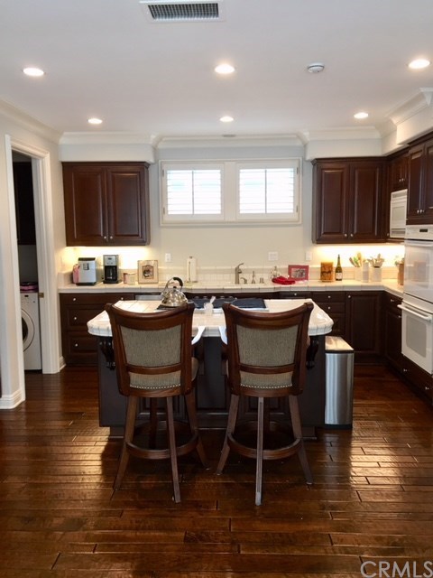 65 Old Course Drive Newport Beach, CA 92660 - Photo 5 of 15 Kitchen has wood floors, double ovens, built-in microwave, newer dishwasher and a SubZero built-in refrigerator. Washer/Dryer included and are located just off the kitchen