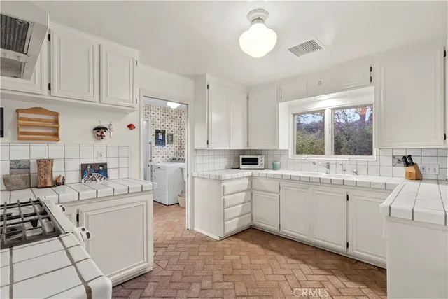 a kitchen with white cabinets and white appliances
