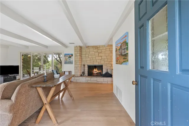 a living room with furniture a fireplace and a floor to ceiling window