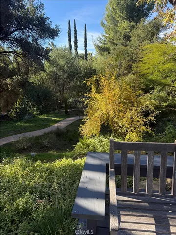 a patio with table and chairs and potted plants