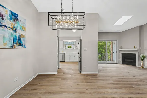 a view of an empty room with a fireplace and chandelier