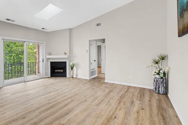 a view of empty room with wooden floor and fireplace