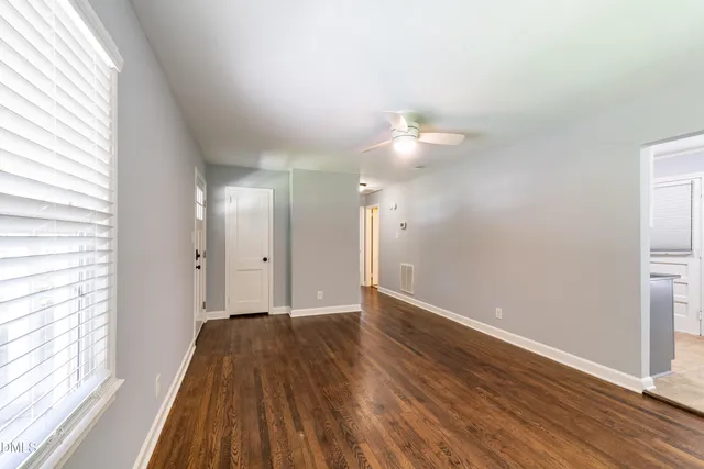 a view of a room with wooden floor and a window