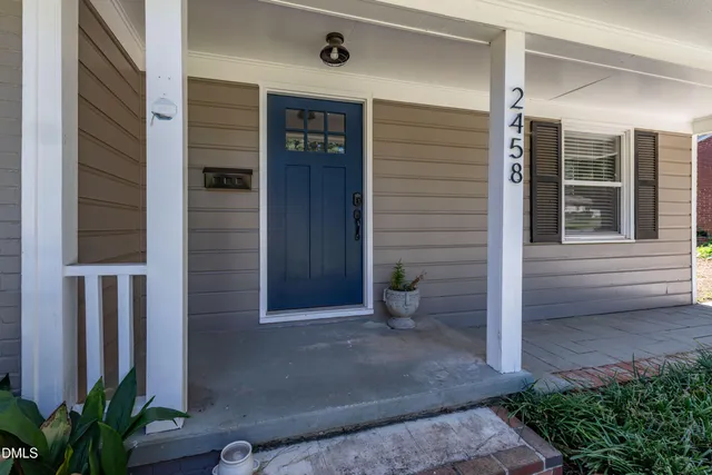 a view of house with potted plants in front of door