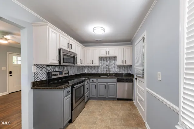 a kitchen with stainless steel appliances granite countertop a stove a sink and a refrigerator