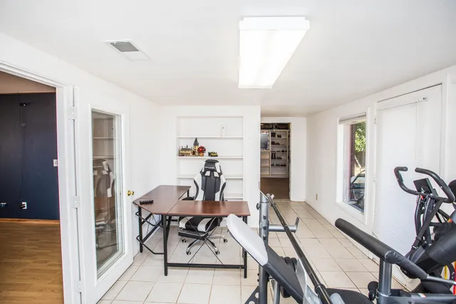 a view of a workspace with furniture and a window