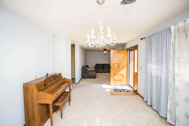 a view of a room with a chandelier fan and windows