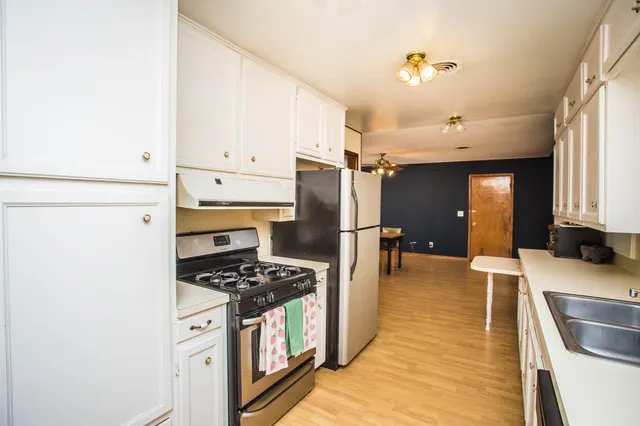 a kitchen with stainless steel appliances a refrigerator sink and cabinets