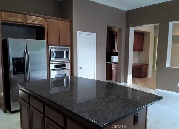 a kitchen with stainless steel appliances granite countertop a sink a microwave and refrigerator