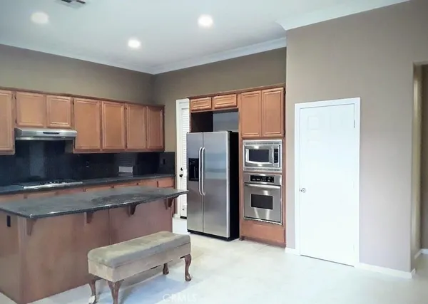 a kitchen with stainless steel appliances granite countertop a refrigerator and a stove top oven