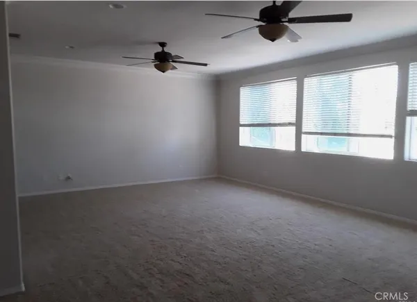an empty room with a window and a ceiling fan
