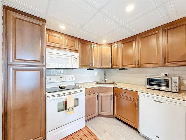 a kitchen with stainless steel appliances granite countertop a refrigerator and a stove top oven