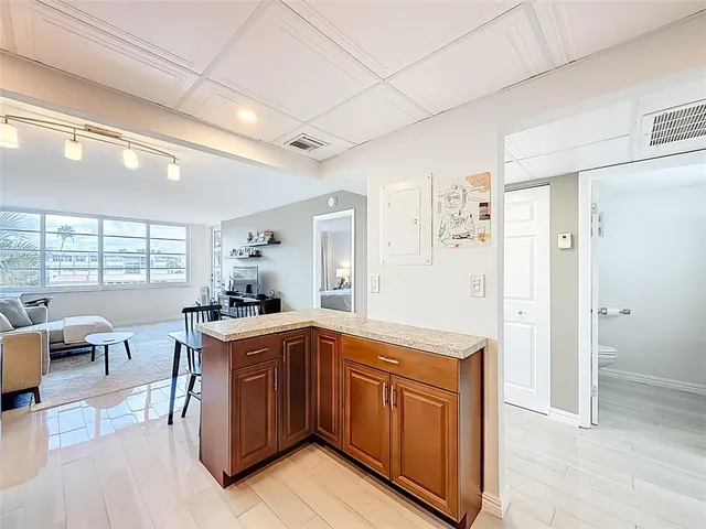 a kitchen with a sink refrigerator and wooden floor