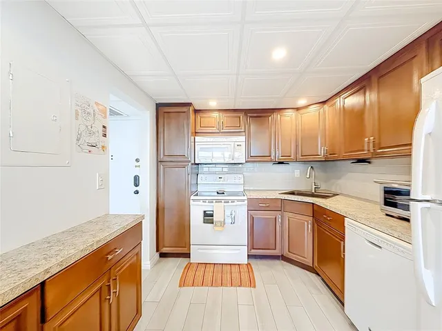 a living room with stainless steel appliances furniture a dining table and chairs