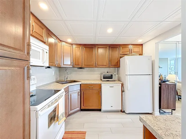 a kitchen with a sink a refrigerator and cabinets