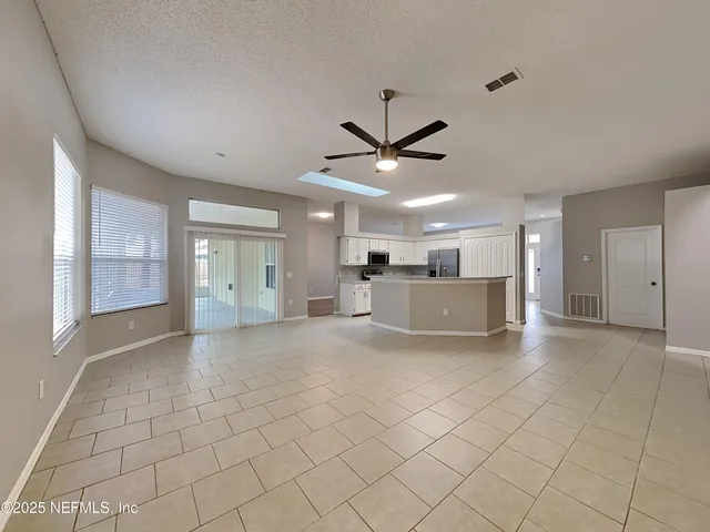 a view of a livingroom with a ceiling fan and window