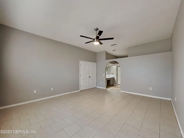 an empty room with a ceiling fan and carpet