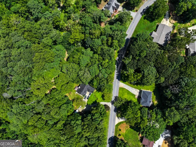 an aerial view of a house with a yard and green space