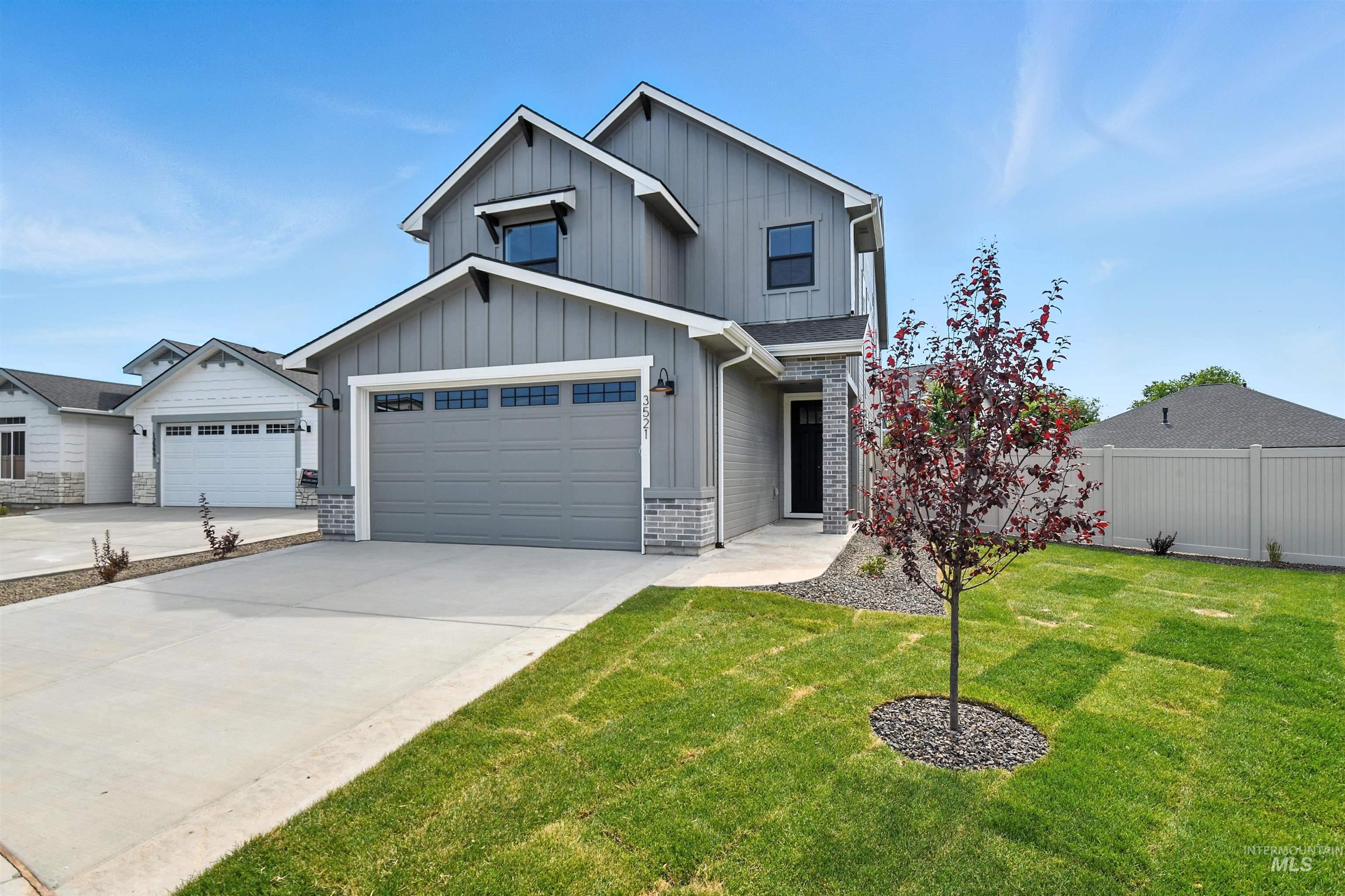 View of front of home featuring board and batten siding, driveway, and a garage