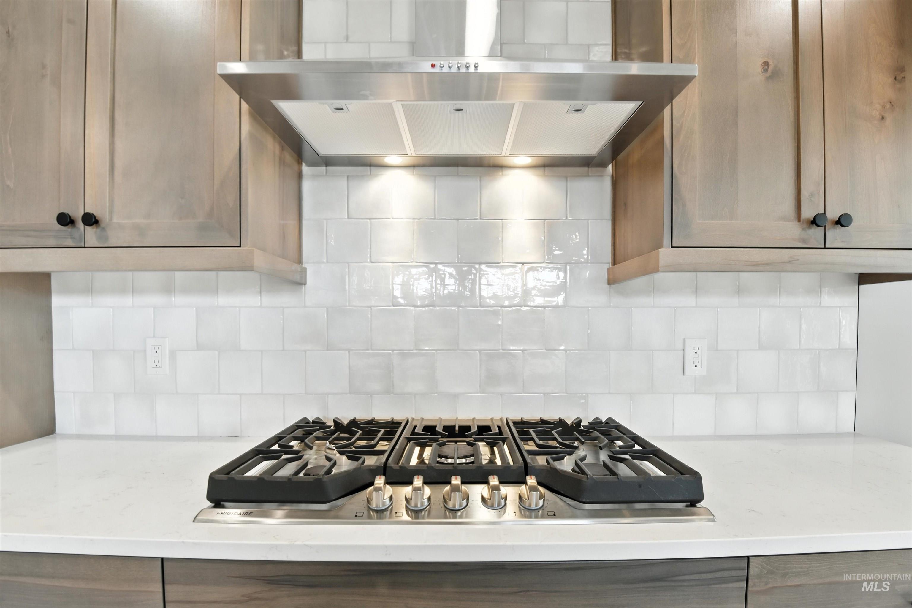 3521 South El Rio Avenue Boise, ID 83709 - Photo 13 of 38 Kitchen with ventilation hood, stainless steel gas stovetop, and backsplash