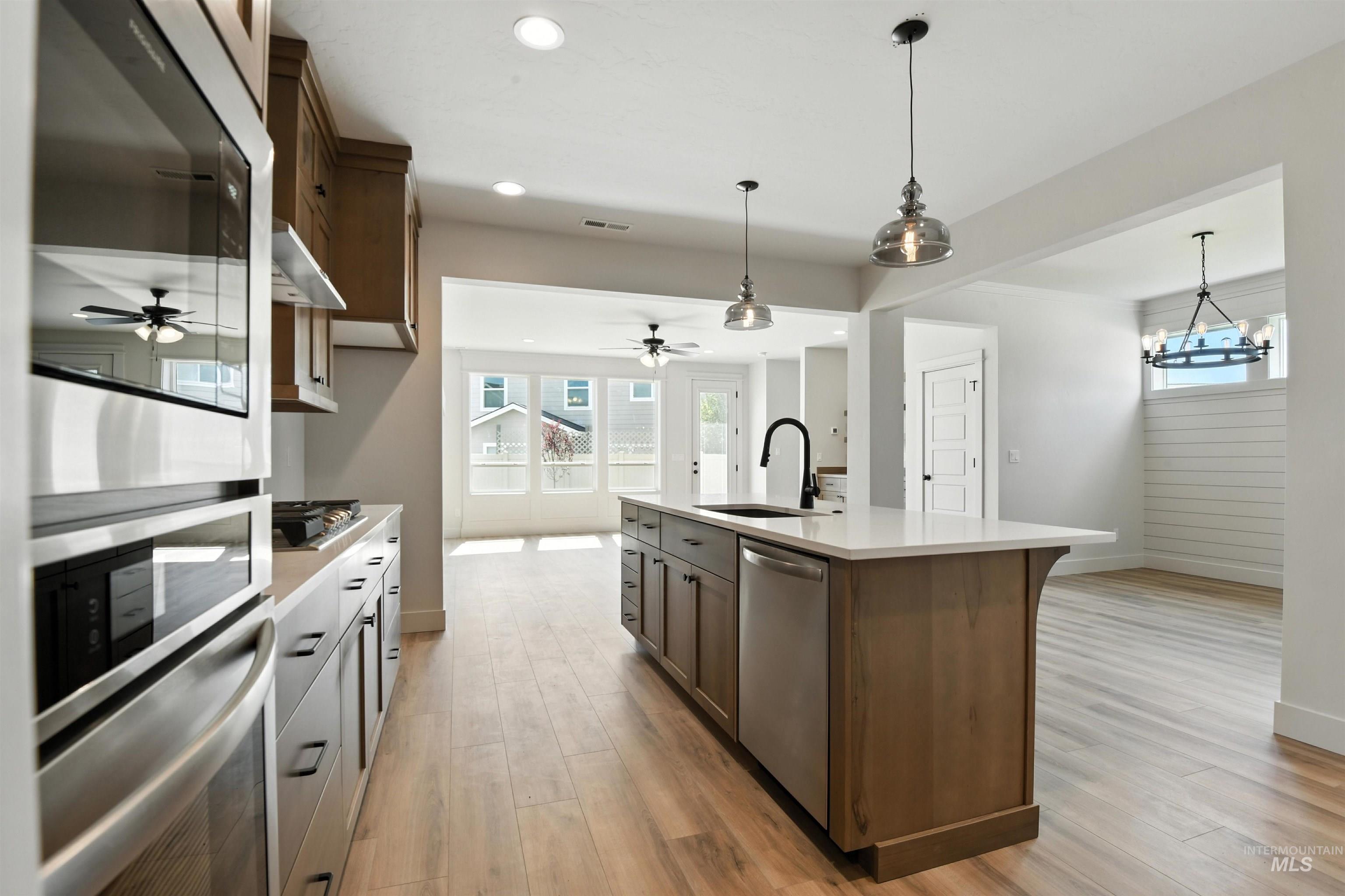 3521 South El Rio Avenue Boise, ID 83709 - Photo 20 of 38 Kitchen featuring appliances with stainless steel finishes, a ceiling fan, light countertops, an island with sink, and recessed lighting