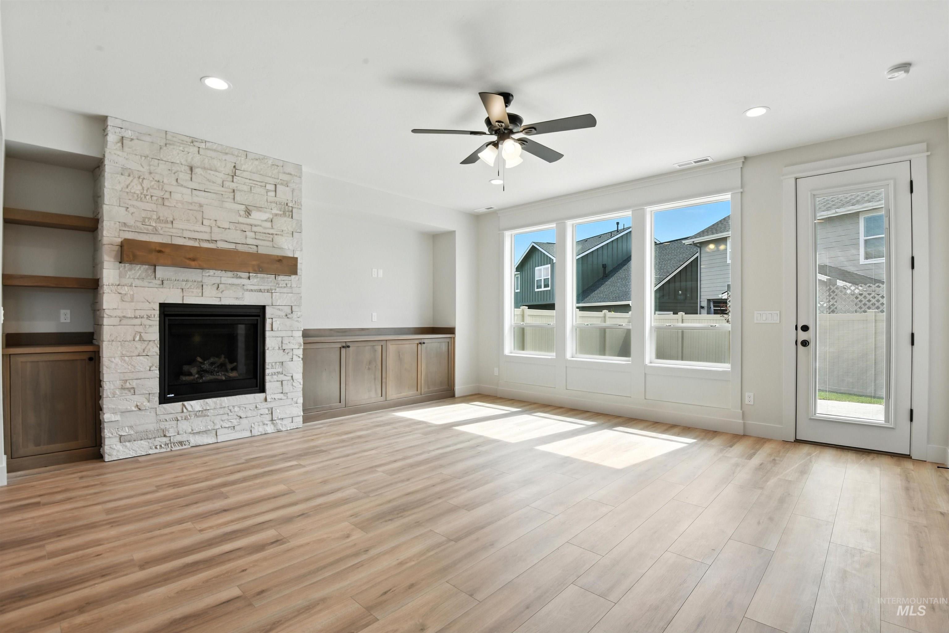 3521 South El Rio Avenue Boise, ID 83709 - Photo 22 of 38 Unfurnished living room featuring ceiling fan, wood finished floors, a stone fireplace, and recessed lighting