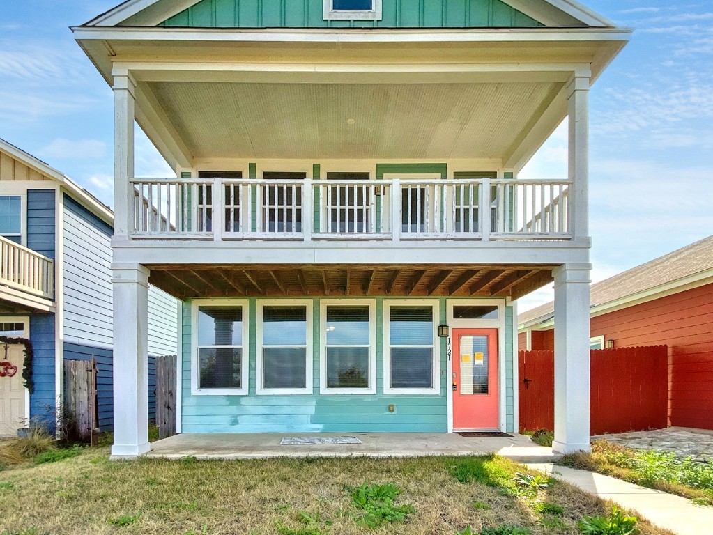 a view of brick house with large windows and a yard