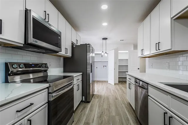 a kitchen with stainless steel appliances a stove microwave and a refrigerator