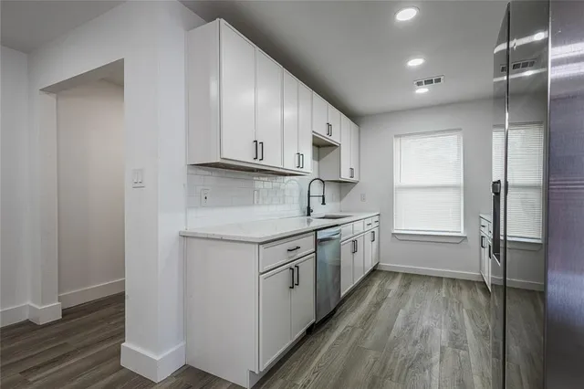 a kitchen with a sink cabinets stainless steel appliances and a window
