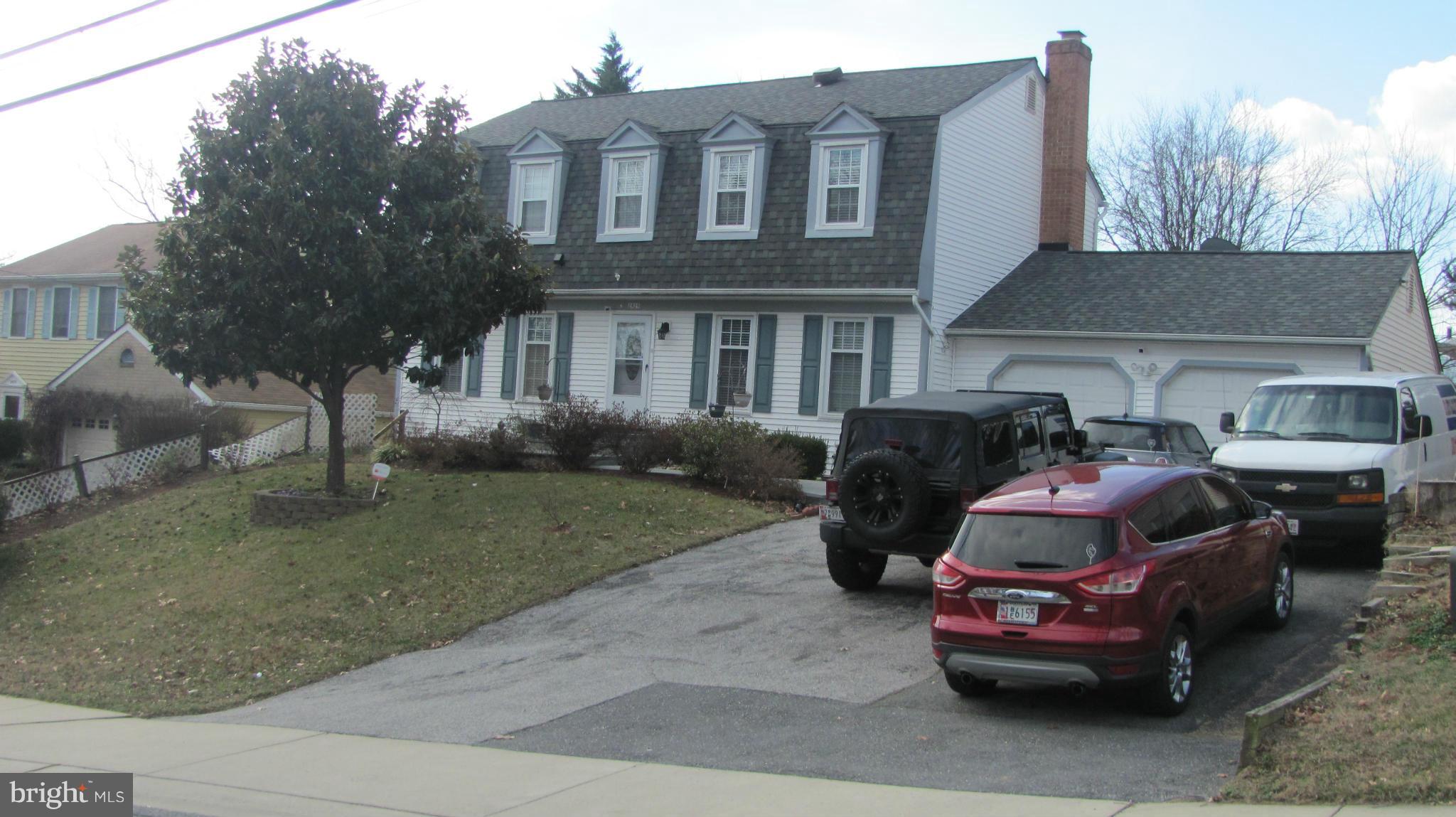 a front view of a house with cars parked