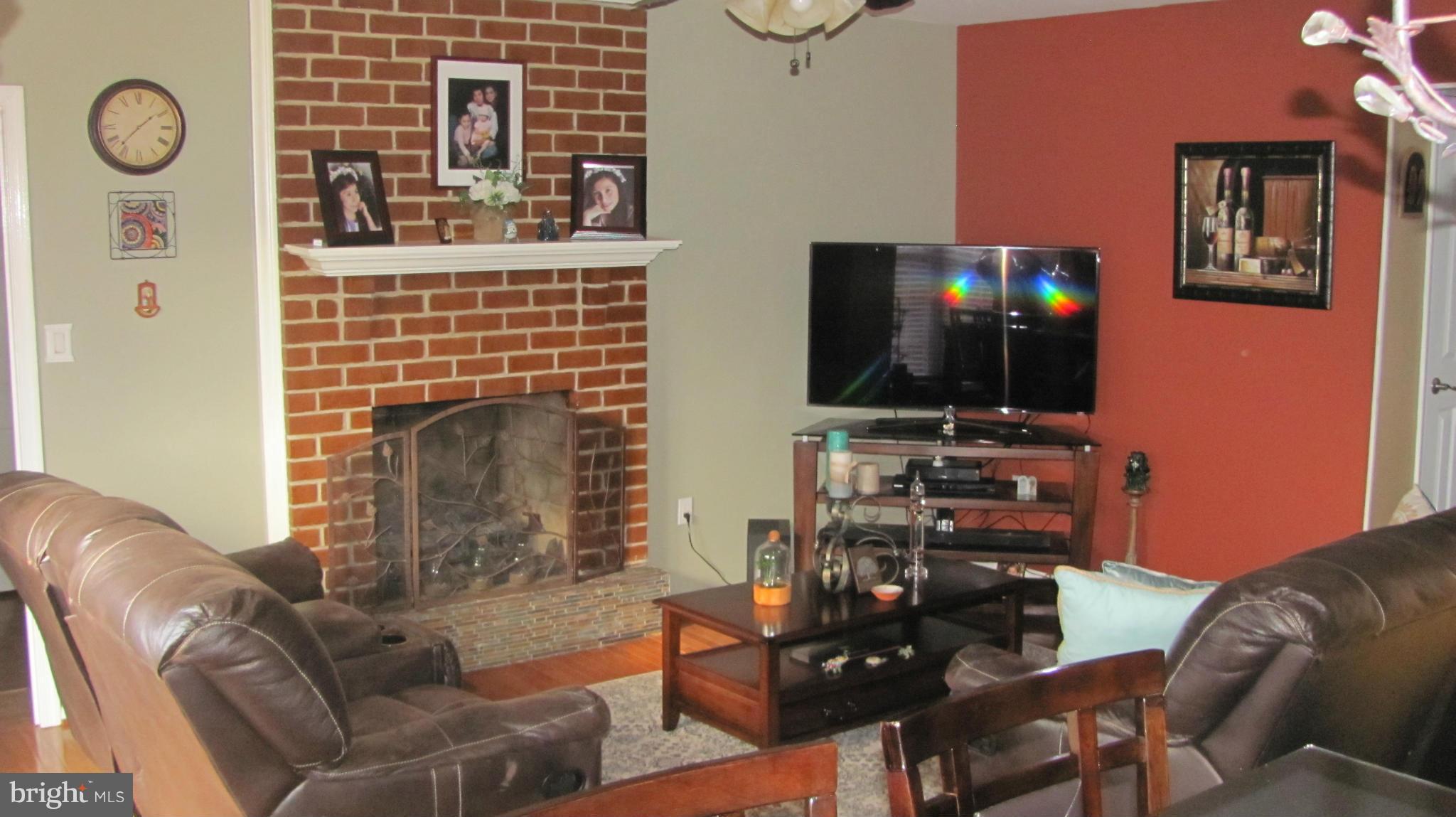 2929 Gracefield Road Silver Spring, MD 20904 - Photo 19 of 25 a living room with furniture a flat screen tv and a fireplace