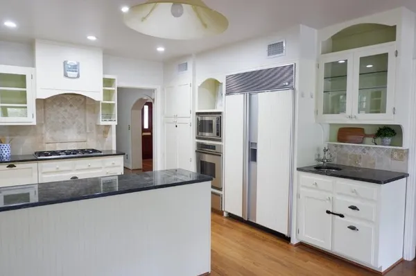a kitchen with stainless steel appliances granite countertop a refrigerator a sink and a stove