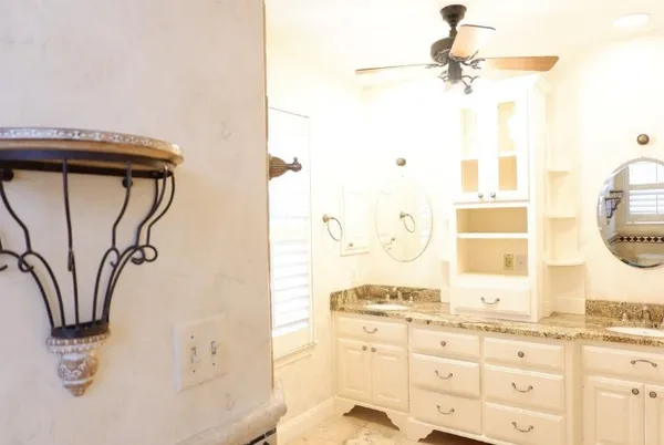 a bathroom with a granite countertop sink a mirror and a shower