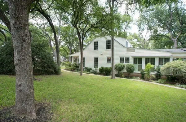 a view of a house with backyard and a tree
